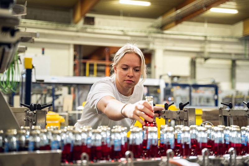 Medarbeider på Hansa Borg Bryggerier som overvåker samlebånd med flasker